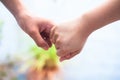 Female childÃ¢â¬â¢s hand holding the hand of elder male shot with a bokeh background and horizontal.